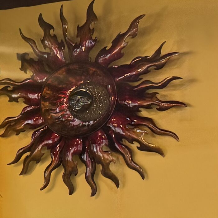 Sol de hojalata repujada en la pared del comedor