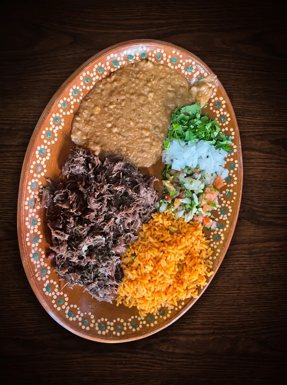 Shredded slow-cooked beef with rice, refried beans, chopped onion, cilantro and pico de gallo.