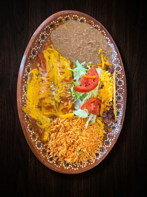Enchiladas under yellow cheese and red sauce with rice, refried beans, lettuce, tomato and shredded cheese.