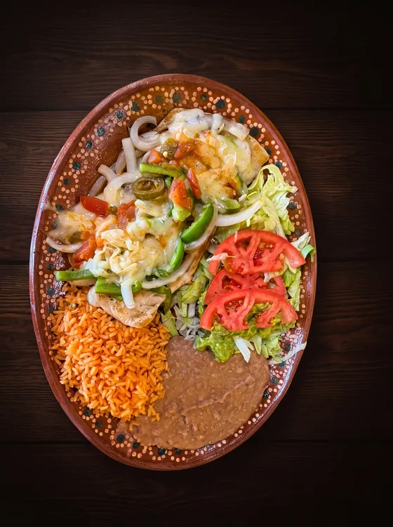 Grilled green pepper, onion and melted cheese, with tomato slices, lettuce, rice and refried beans.
