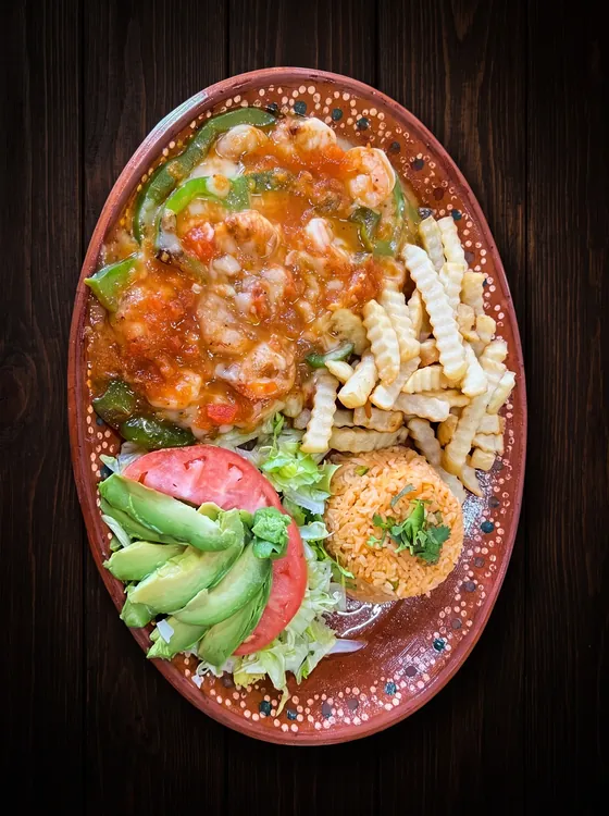 A second view: shrimp under red sauce with peppers, crinkle-cut fries, rice, sliced avocado and tomato.